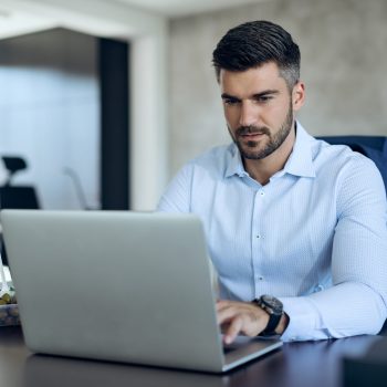 male-entrepreneur-using-computer-while-working-office-scaled-1.jpg